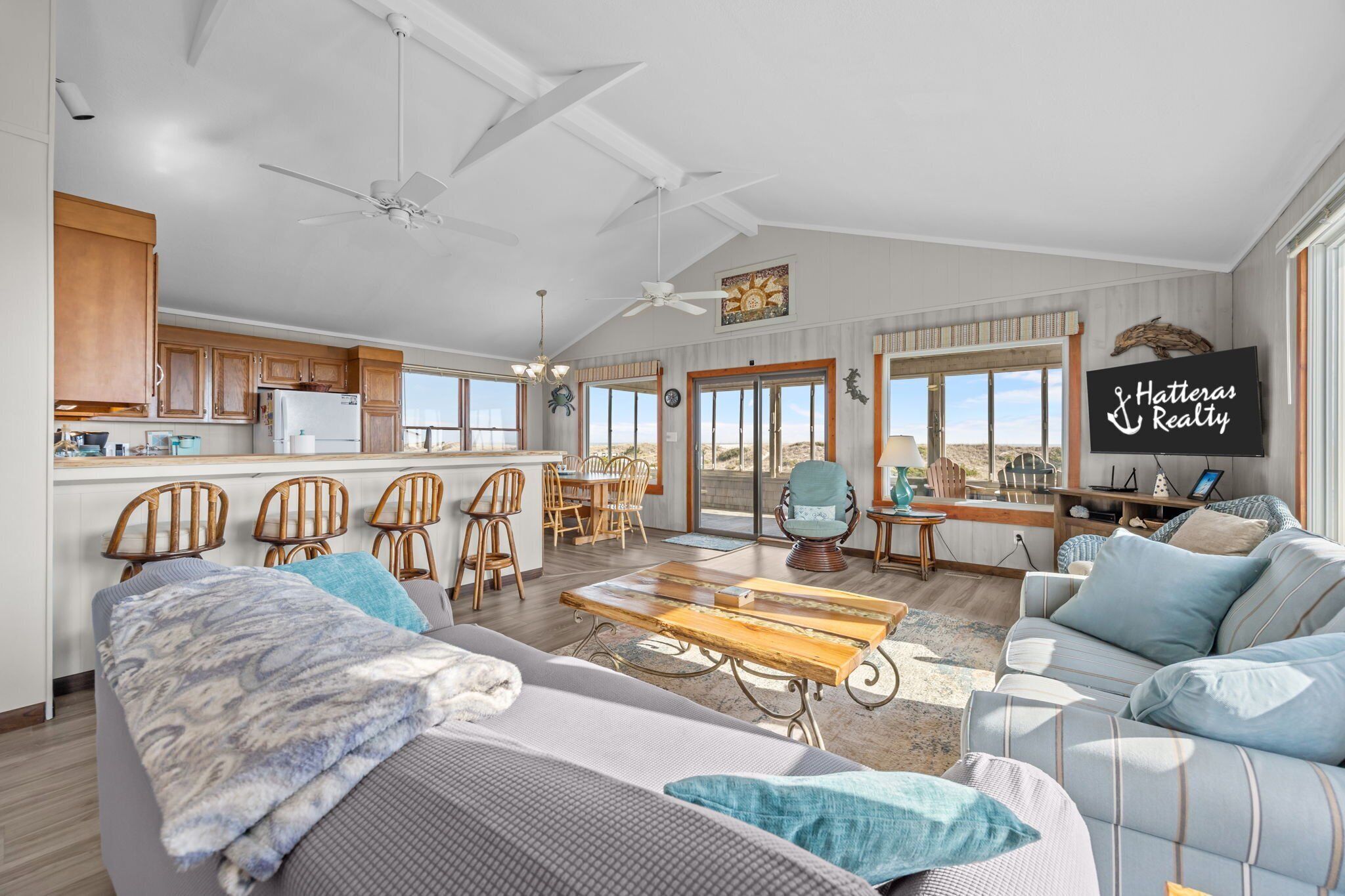A spacious living area with a large sofa, a dining table, and a kitchen in the background.