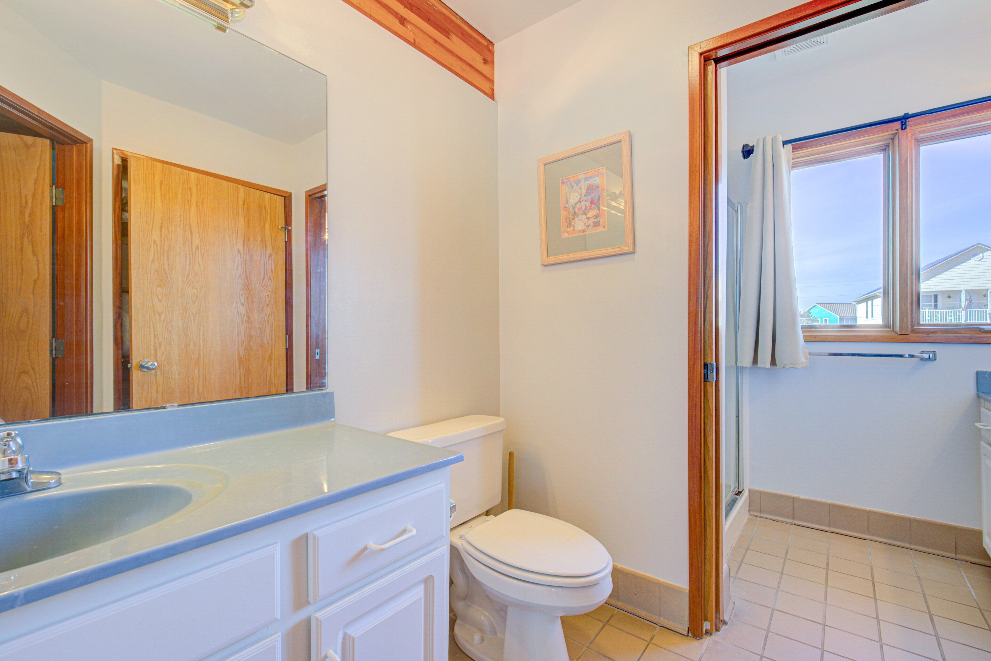 A bathroom with a sink, toilet, and a mirror.