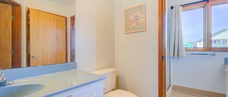 A bathroom with a sink, toilet, and a mirror.