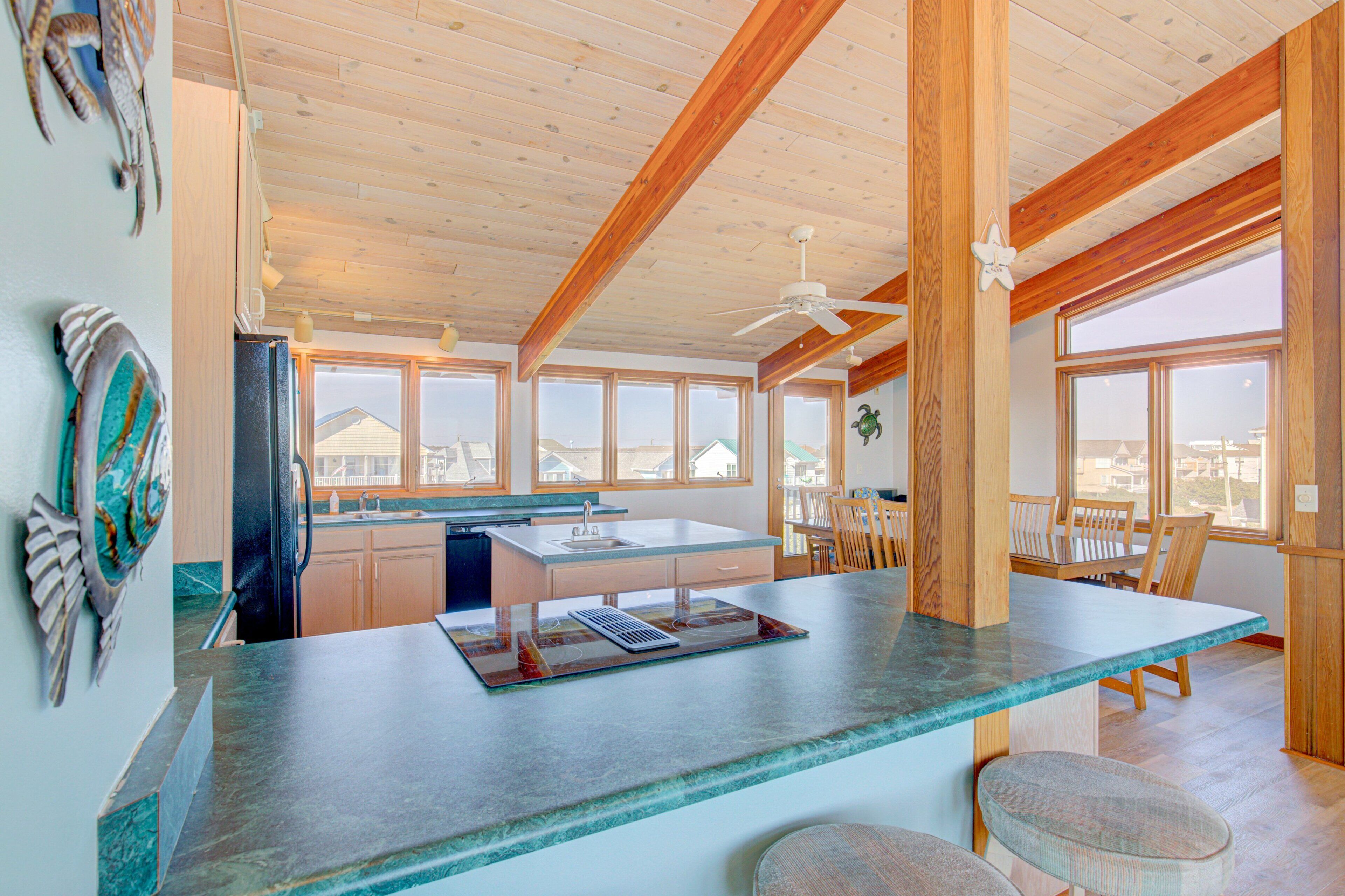 A kitchen with a large island, wooden beams, and a view of the city.