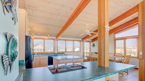 Una cocina con una isla grande, vigas de madera y vistas a la ciudad.