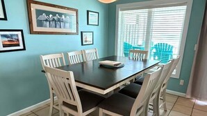 A dining area with a table and chairs, a pendant light, and a window with blinds. - Dog-friendly oceanfront home with beach access, a washer/dryer & central AC (Surf City)