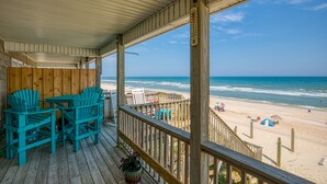 A wooden deck with turquoise Adirondack chairs and a view of the beach. - Dog-friendly oceanfront home with beach access, a washer/dryer & central AC (Surf City)