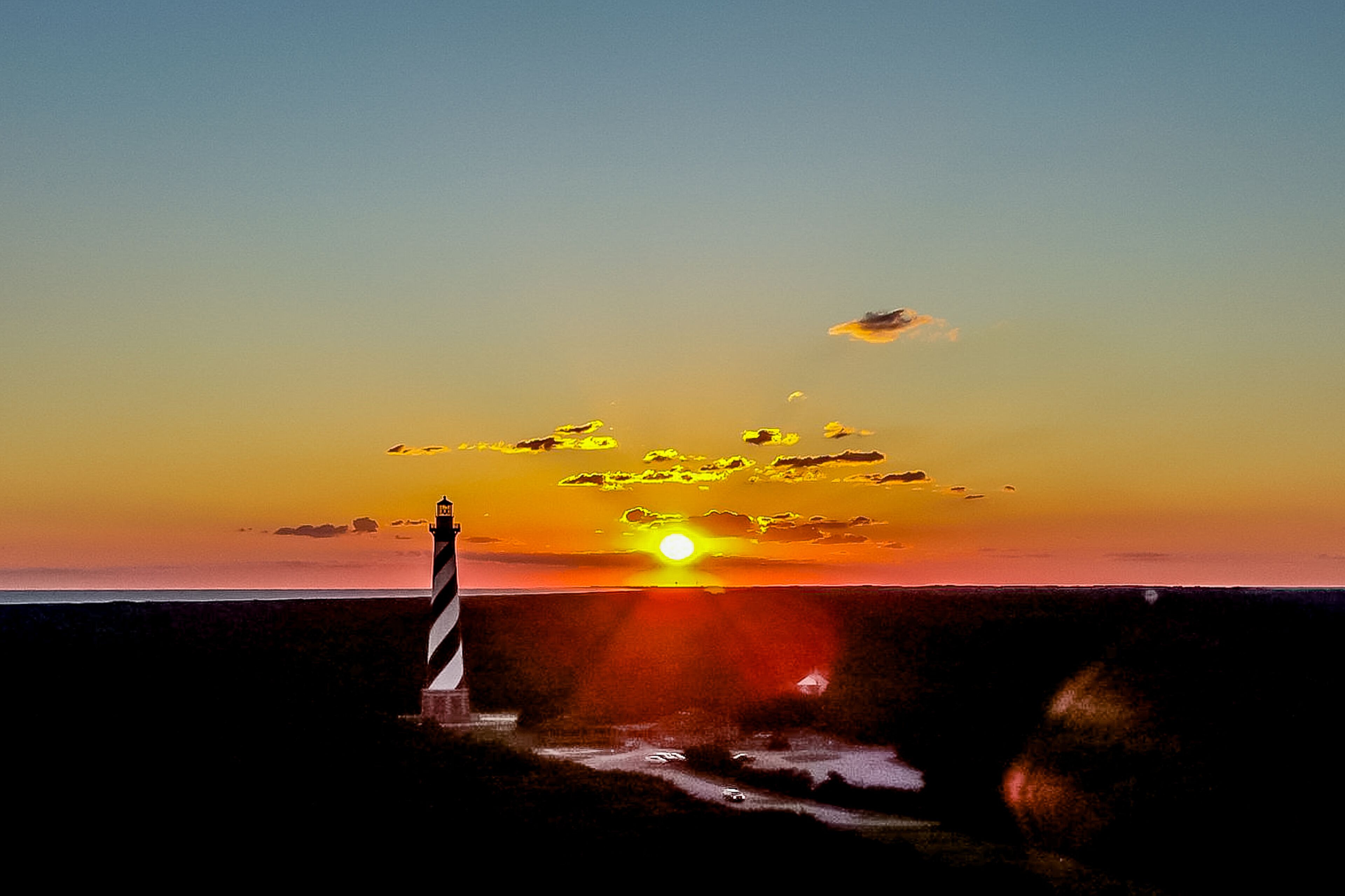 Een vuurtoren bij zonsondergang, met heldere lucht.