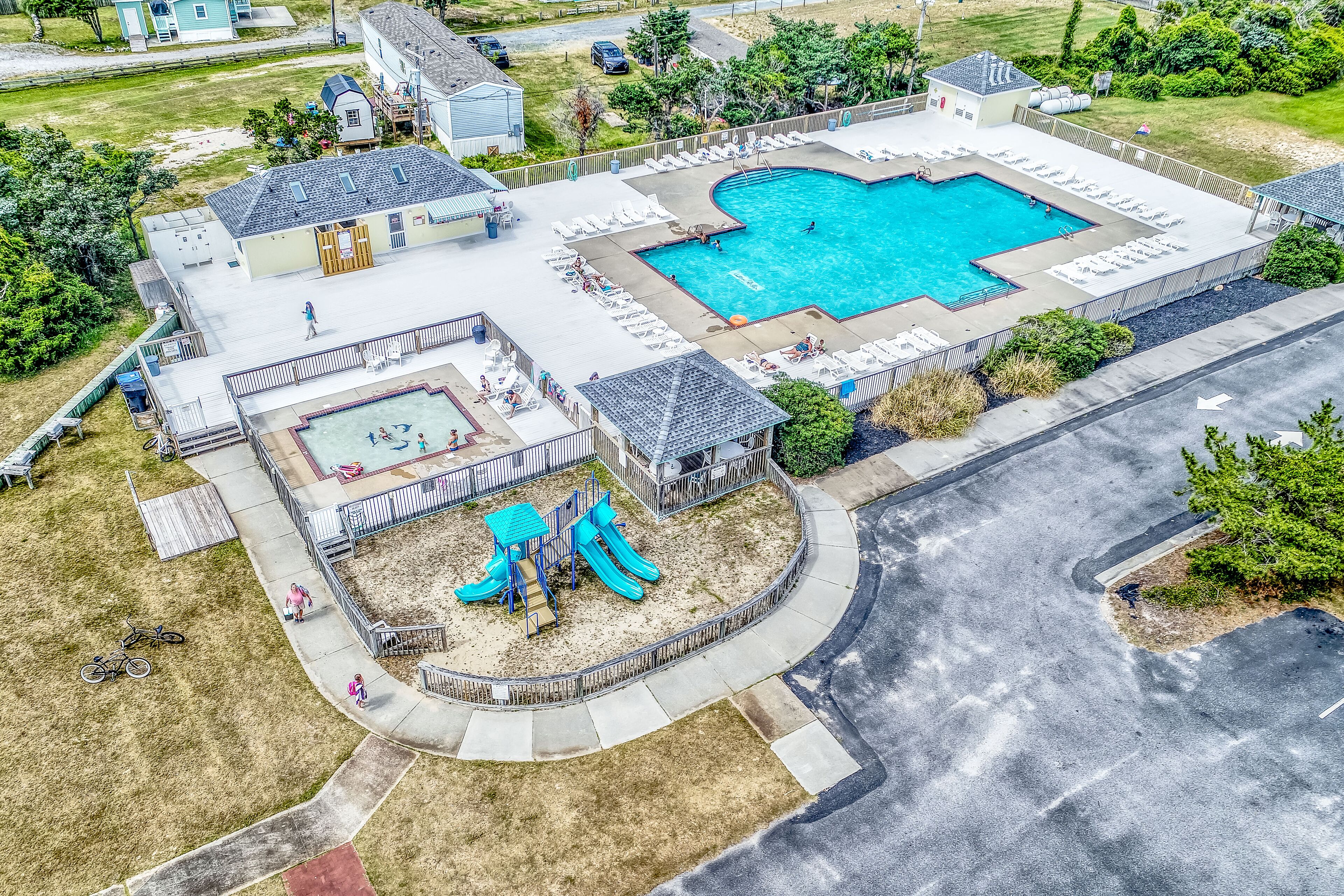 Zona residencial com piscina, parquinho infantil e área de varanda coberta.