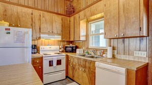 A kitchen with wooden cabinets, a refrigerator, stove, microwave, sink, and dishwasher. - Oceanfront Home w/Incredible Views, Private Boardwalk to the Beach, & Free WiFi (Holden Beach)