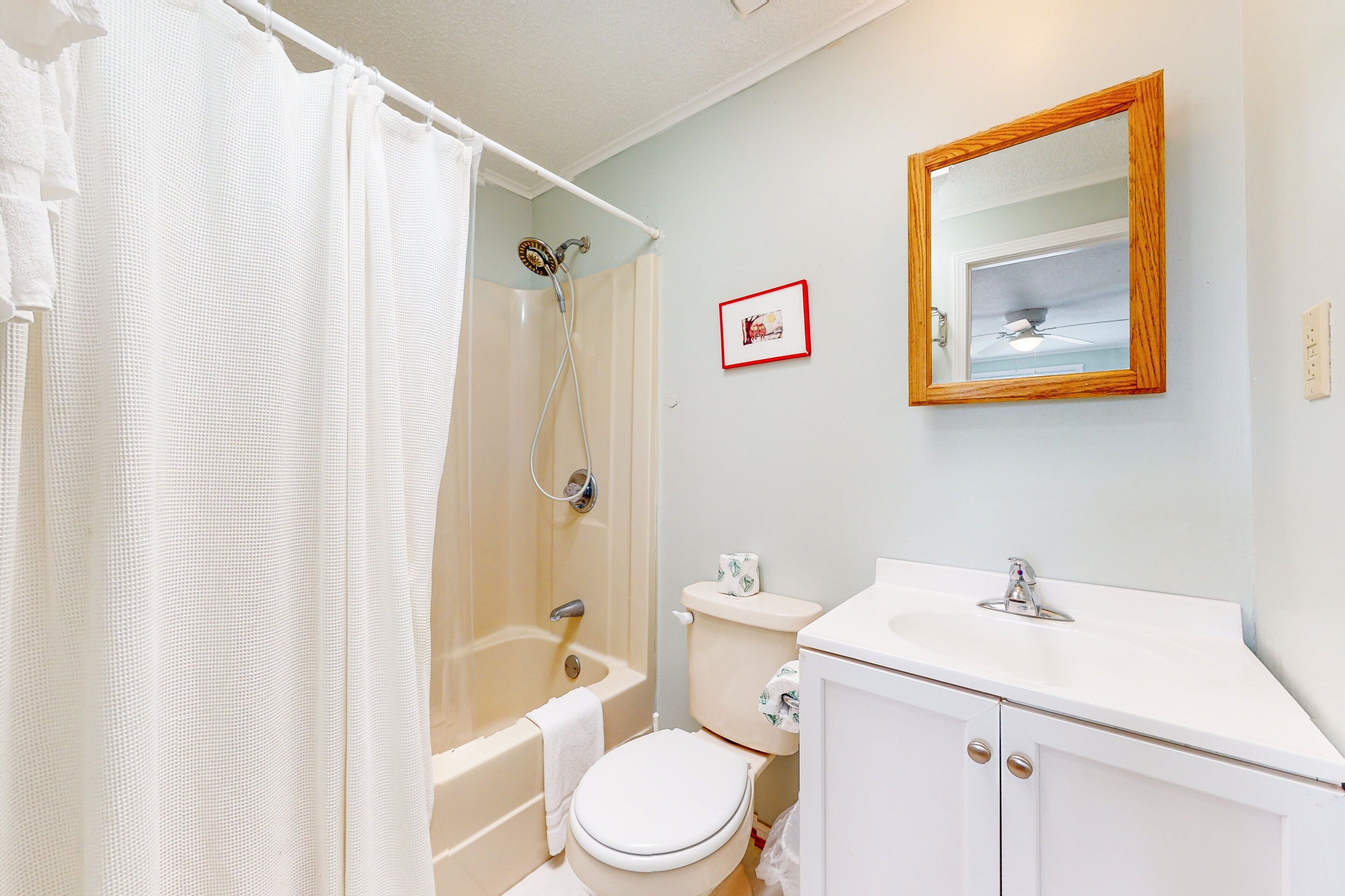 A bathroom with a bathtub, toilet, and sink.