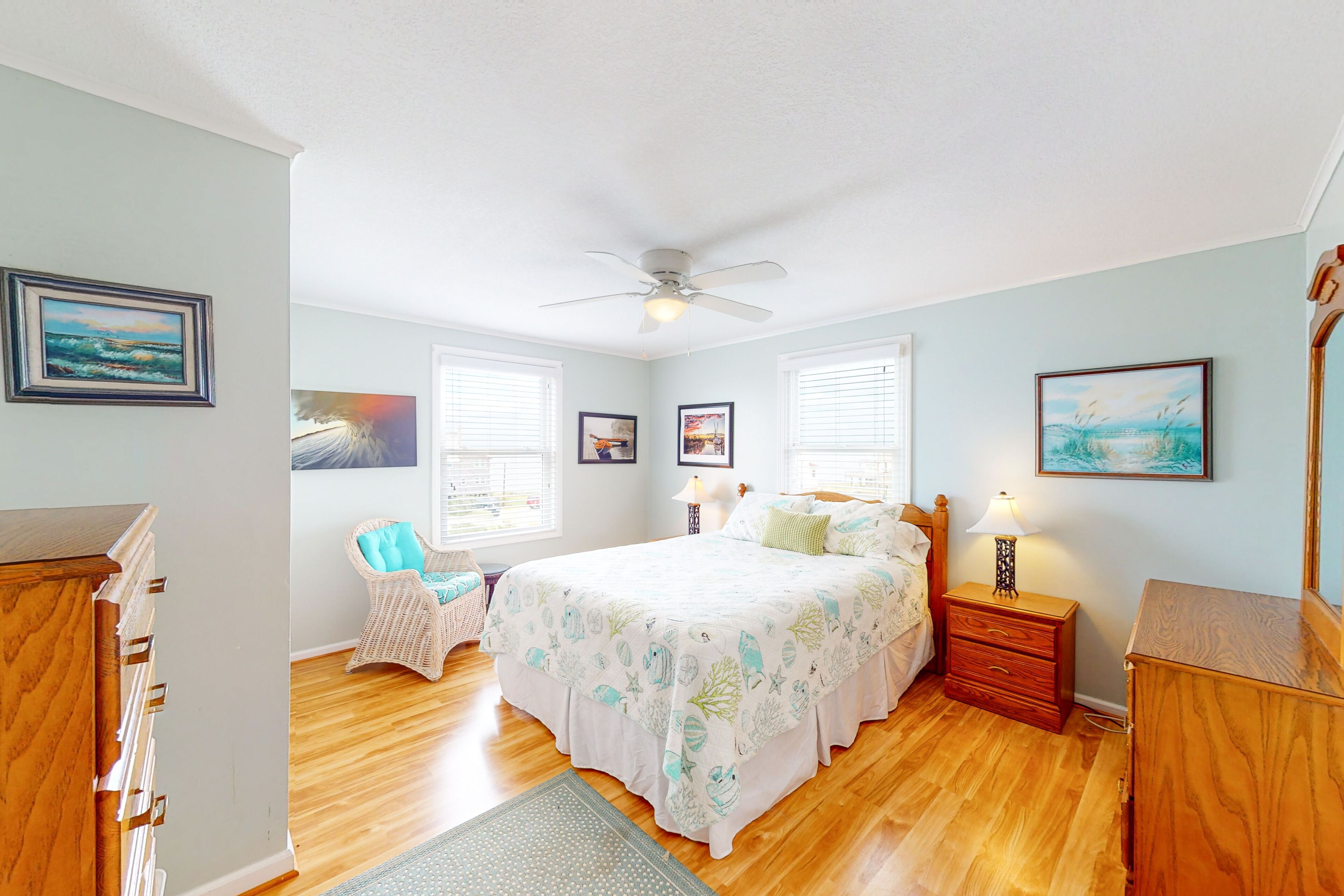 Une chambre à coucher avec un lit, une chaise, une commode et une table de chevet.