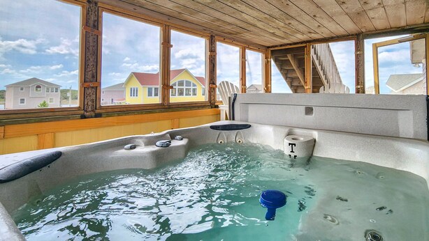 Ein Whirlpool mit Blick auf Häuser durch große Fenster.