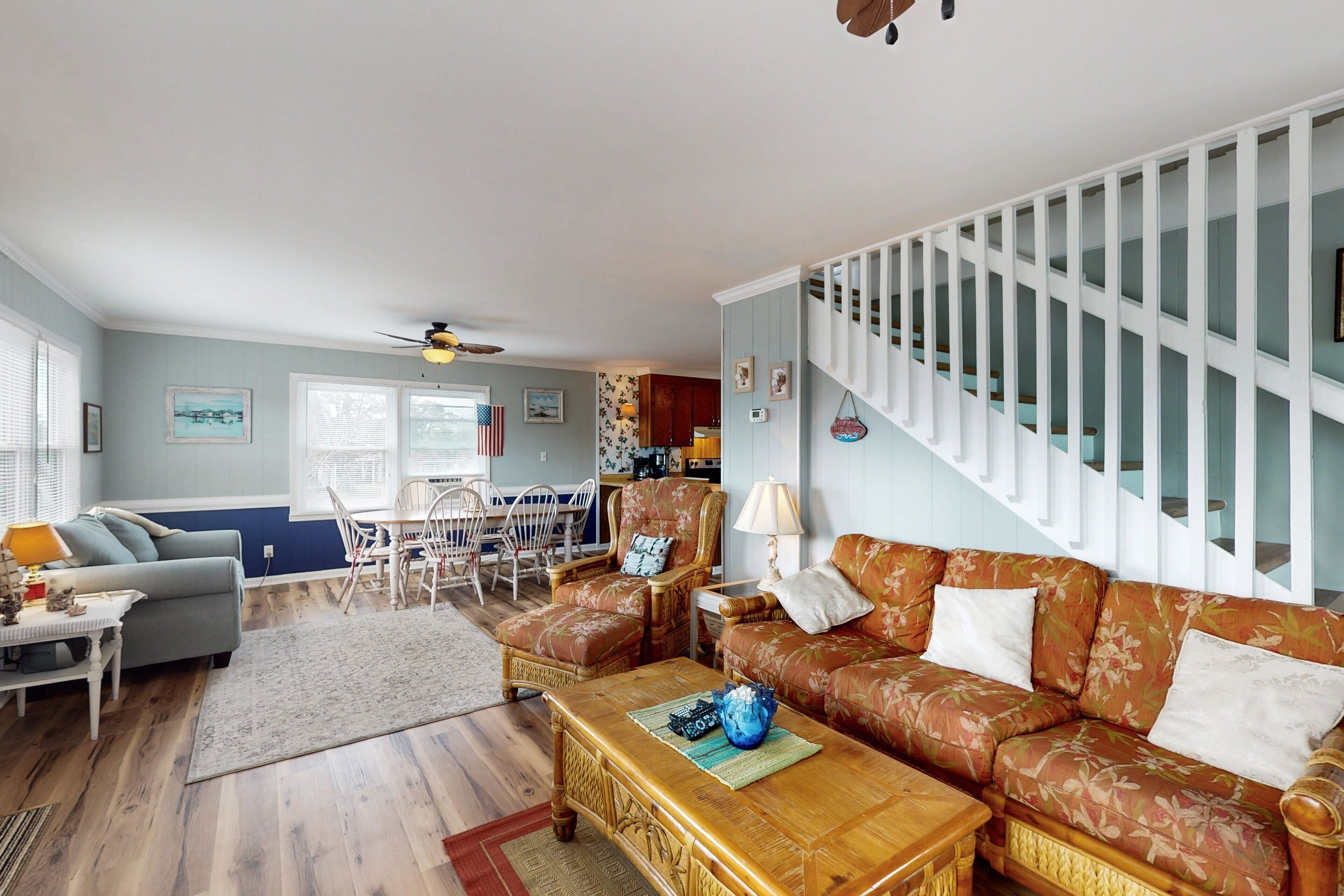 A spacious living room with a sofa, a coffee table, and a dining area with chairs.