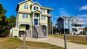 A two-story house with a front porch and a staircase leading to the upper floor. - Spacious home with private pool, hot tub, pool table & central AC (Waves)