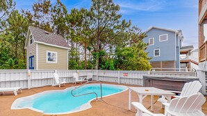 A backyard with a swimming pool, white deck chairs, and a barbecue area. - Spacious home with private pool, hot tub, pool table & central AC (Waves)