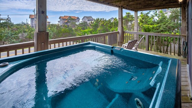 Ein Whirlpool auf einer Holterrasse mit Blick auf Häuser und Bäume.