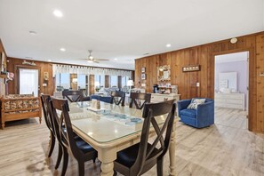 Amplia sala de estar con una mesa de comedor, sillas, un sofá y un sillón azul.