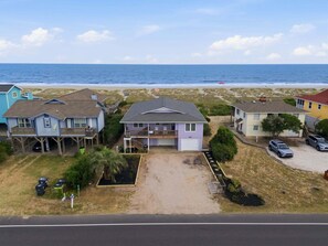 Zona residencial costera con casas, una playa y una vista despejada del océano.