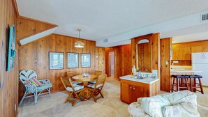 Interior acogedor de una cabaña con comedor, cocina y sofá.