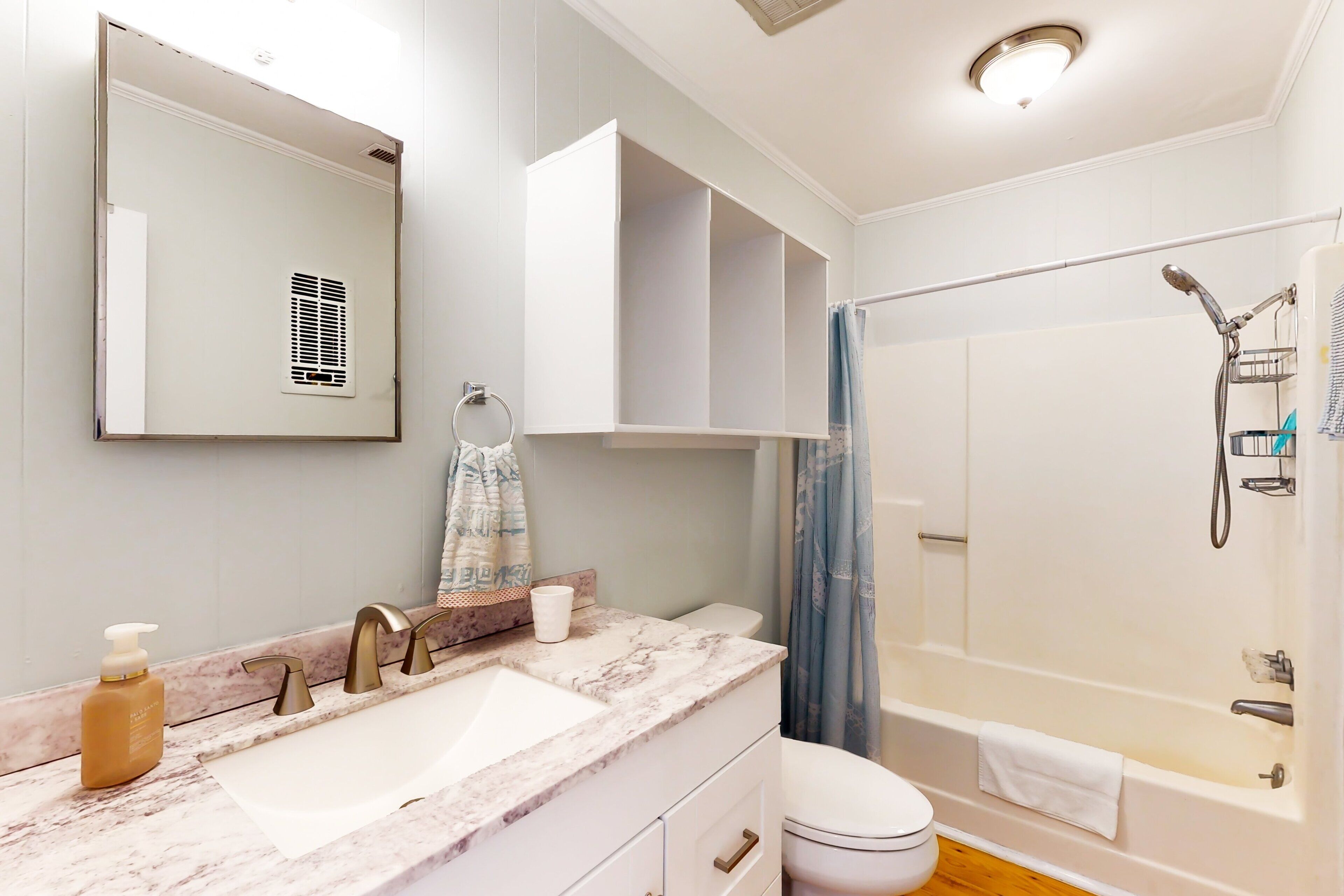 A modern bathroom with a marble sink, a toilet, a bathtub, and a shower.
