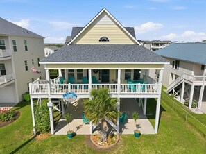 A two-story house with a balcony, a small porch, and a flag. - Family-Friendly Canal Home - Steps to the Beach (Surf City)