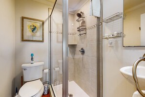 Une salle de bain avec des toilettes, une douche et un lavabo.