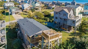 Zona residencial costera con casas que tienen terrazas elevadas y vista al mar.