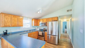 Una cocina moderna con armarios de madera, electrodomésticos de acero inoxidable y encimera azul.