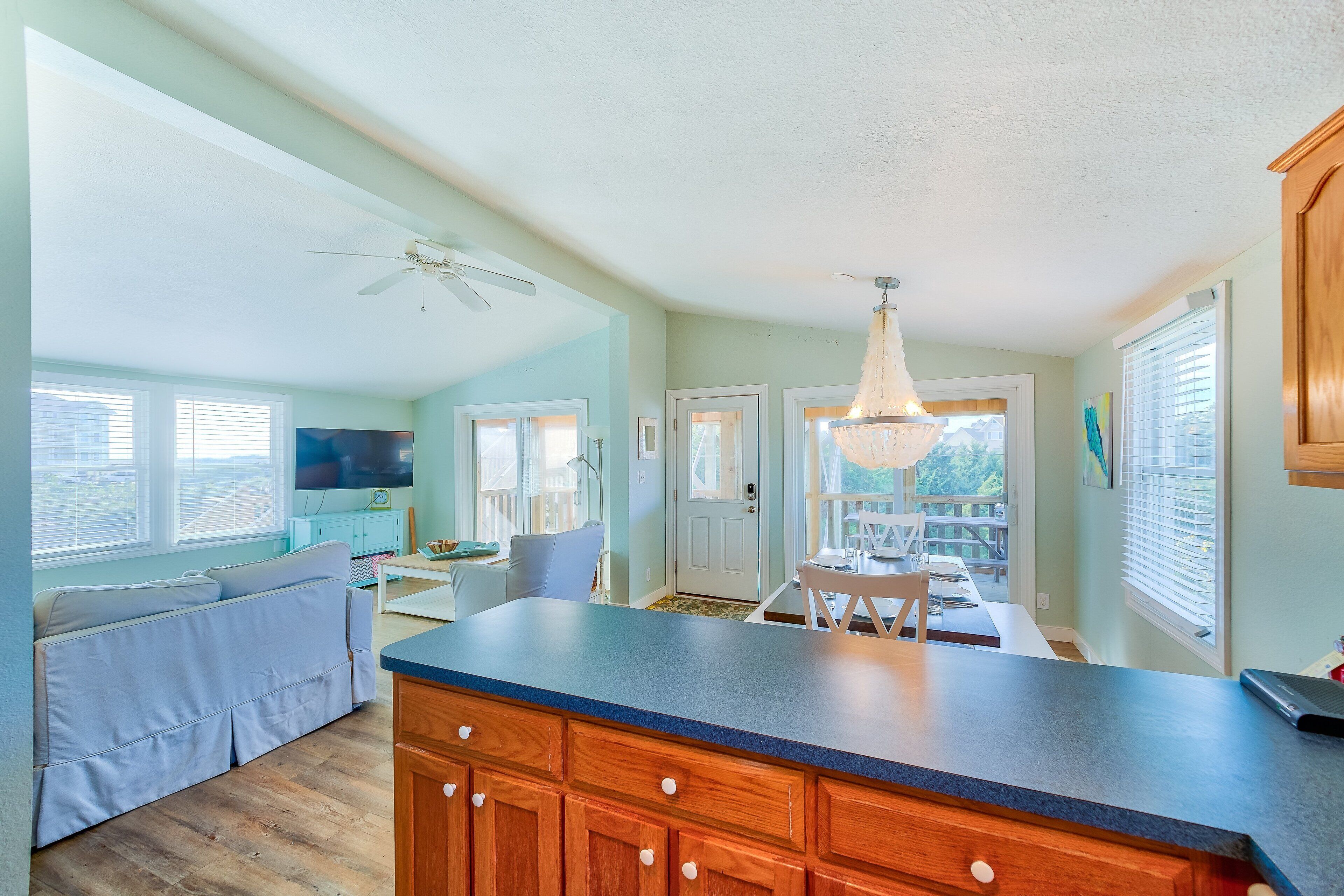 A spacious kitchen with wooden cabinets, a large island, and a ceiling fan.