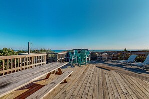A wooden deck with picnic tables and chairs, overlooking a beach. - Oceanfront Escape with Private Beach Access, Expansive Deck & Separate Guest Apartment! (Topsail Beach)
