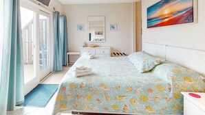 Una camera da letto con un letto, una scrivania, una sedia, una televisione e un quadro appeso al muro.