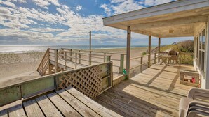 A wooden deck with a view of the beach and ocean, a covered seating area, and a small table. - 3BR Oceanfront Topsail Beach Cottage | Dog Friendly! (Topsail Beach)