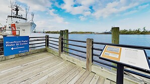 Une jetée en bois avec un panneau indiquant la direction du Riverfront Park/Water St Center.
