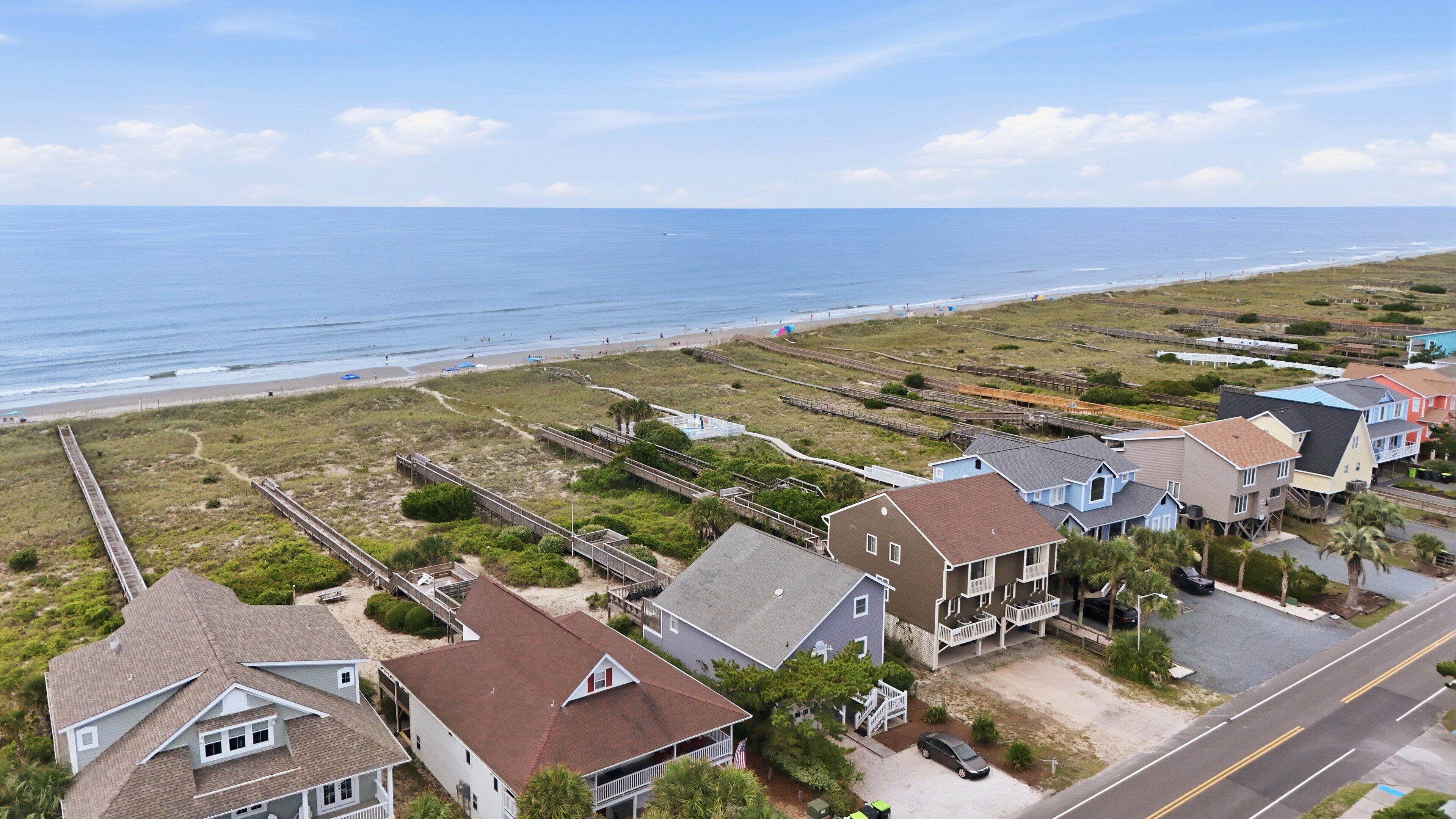 Une zone résidentielle côtière comprenant des maisons, une plage et une promenade en bord de mer.