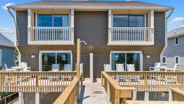 A two-story house with a wooden deck and outdoor seating. - Oceanfront home with WiFi, central AC, washer/dryer  - dogs welcome (Holden Beach)
