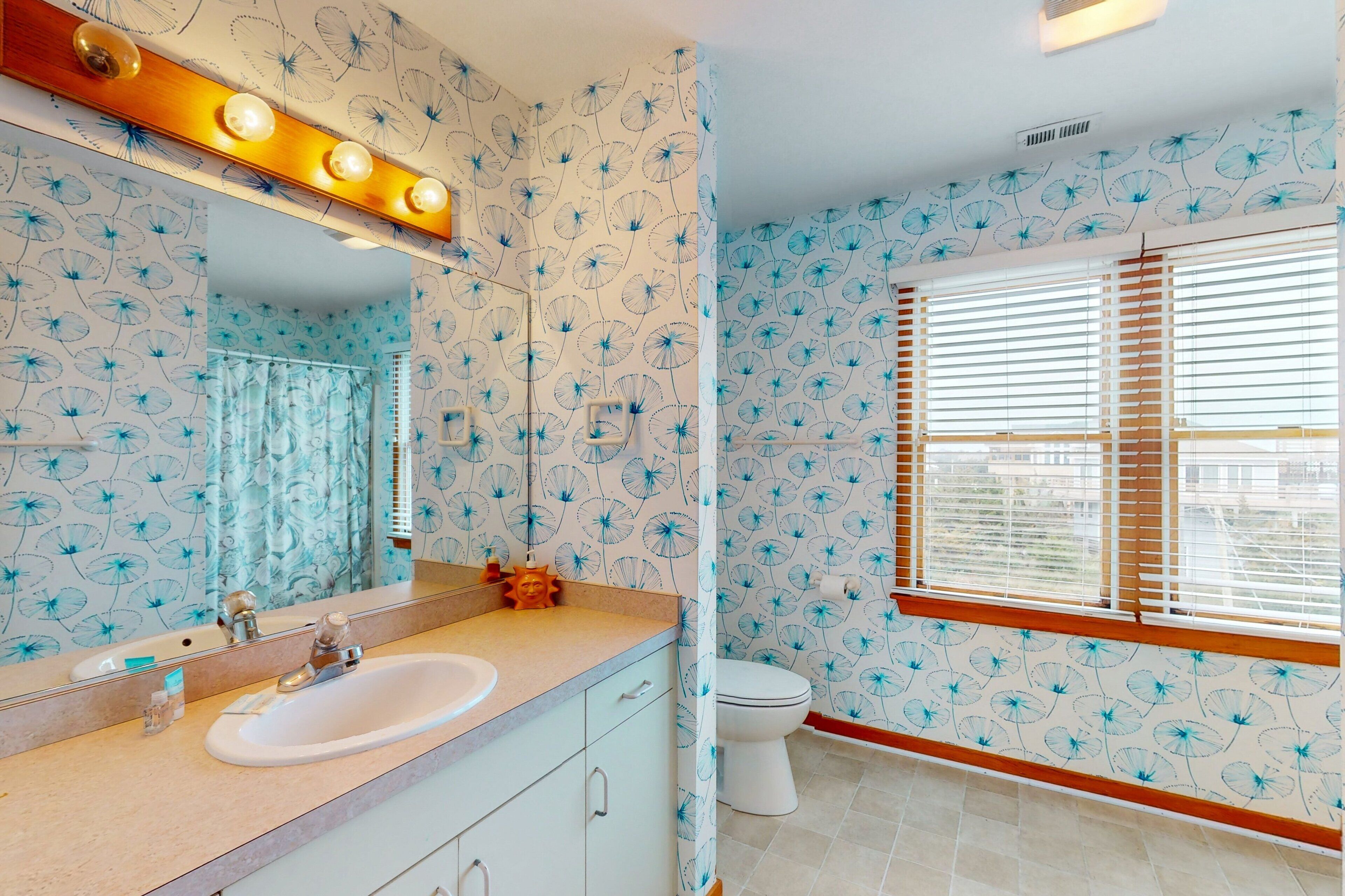 A bathroom with a sink, mirror, and toilet.