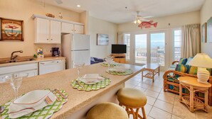 A spacious kitchen with a dining area, a television, and a balcony with a view.