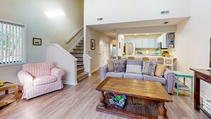 Un salón espacioso con escaleras, una zona de cocina y un comedor.