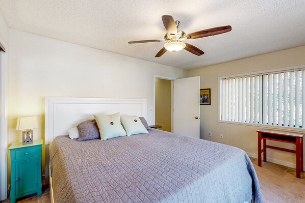 A bedroom with a bed, a ceiling fan, a window with blinds, and a nightstand. - Beautiful townhome with pool, patio, Pack-N-Play, internet, W/D, & central AC (Wilmington)