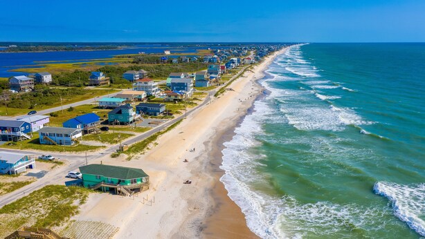 A coastal town with beachfront properties, a sandy beach, and ocean waves. - Dog-friendly beachfront home with beach access, ocean views (North Topsail Beach)