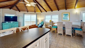 A spacious kitchen with a large island, wooden ceiling beams, and a ceiling fan. - Dog-friendly beachfront home with beach access, ocean views (North Topsail Beach)