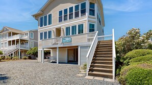 A multi-story beachfront property with a covered porch, a staircase, and a sign reading "My Floppy House." - Dog-friendly marsh view home with large deck, close to beach access (Holden Beach)