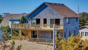 A two-story house with a balcony, a visible staircase, and a gravel driveway. - Brigadune 143: Dog Friendly, Ocean view, 3 lots from beach (Avon)