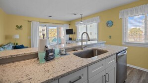 A kitchen with a sink, countertop, and cabinets.