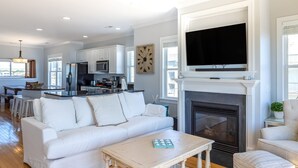 A spacious living area with a white sofa, a coffee table, and a fireplace. - Elegant beachfront escape with private boardwalk, free WiFi, & furnished balcony (Carolina Beach)