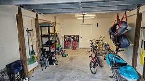 Eine Garage mit Fahrrädern, Kajaks und verschiedenen Werkzeugen.