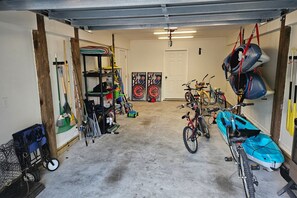 Eine Garage mit Fahrrädern, Kajaks und verschiedenen Werkzeugen.