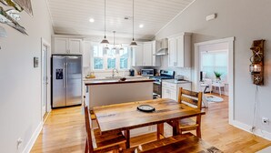 A modern kitchen with white cabinetry, a central island, and pendant lighting.