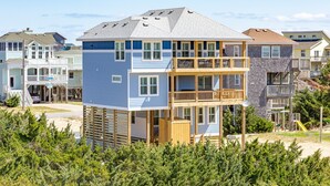 Ein mehrstöckiges Wohngebäude mit einem Balkon im zweiten Stock, umgeben von weiteren Häusern.