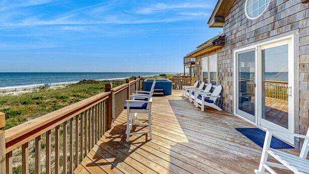 A wooden deck with outdoor seating and a view of the ocean. - Oceanfront dog-friendly home with private hot tub, ocean-view sundecks, AC & W/D (Frisco)