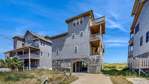 A multi-story building with a balcony on the second floor, a covered entrance, and a sign that reads "Simplicity." - Oceanfront dog-friendly home with private hot tub, ocean-view sundecks, AC & W/D (Frisco)