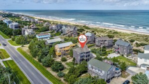An aerial view of a coastal residential area with houses, a beach, and a road. - Hooked on Beach Life #16-AC: Dog-Friendly, Ocean View, Shared Pool (Avon)