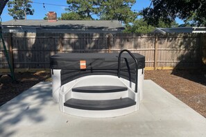A hot tub with steps and a ladder, surrounded by a wooden fence and trees. - Beach - Please:  Dog-Friendly, Hot Tub, Step-free (Oak Island)